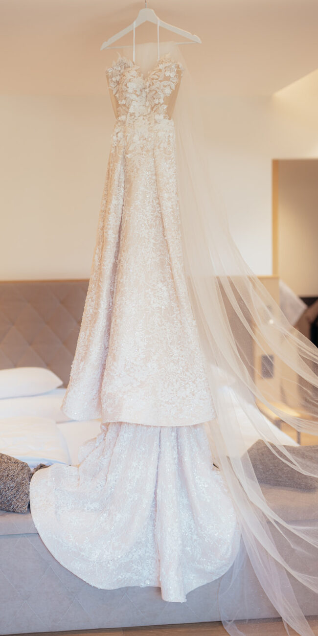 Detailaufnahme eines eleganten Spitzenbrautkleids bei exklusiver Hochzeit im Das Lakeside Tirol