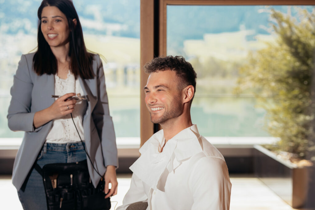 Elegantes Brautpaar in moderner Suite mit Blick auf den Walchsee während luxuriösem Hochzeitsshooting