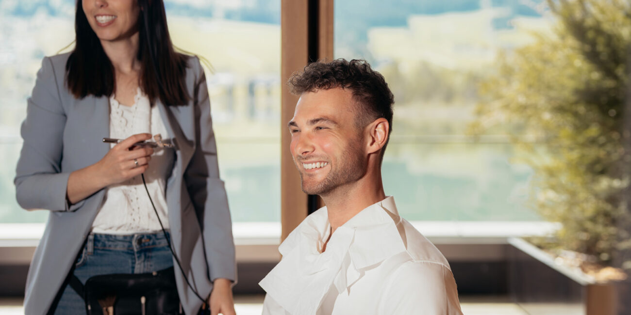 Elegantes Brautpaar in moderner Suite mit Blick auf den Walchsee während luxuriösem Hochzeitsshooting