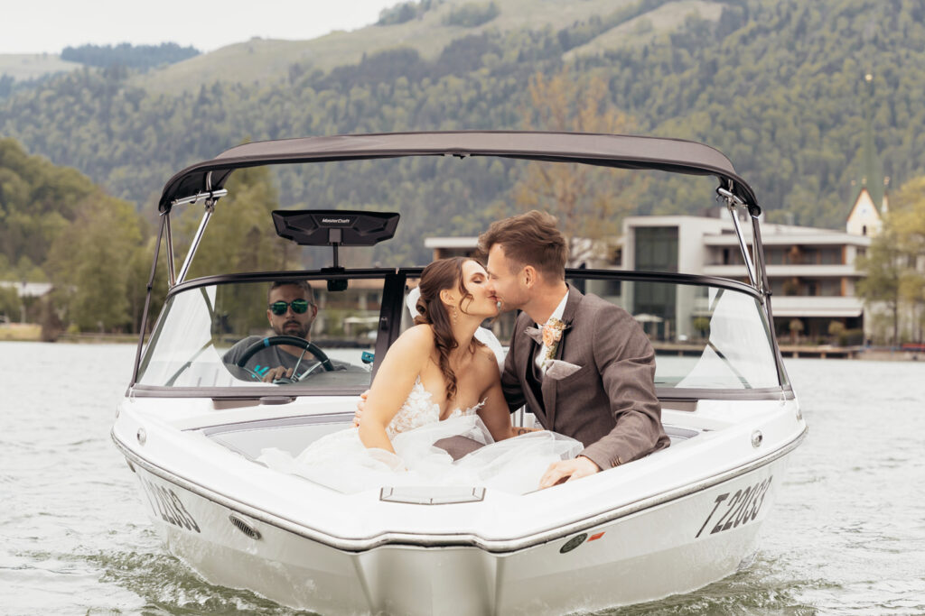 Elegantes Brautpaar im Motorboot bei exklusiver Hochzeit am Walchsee