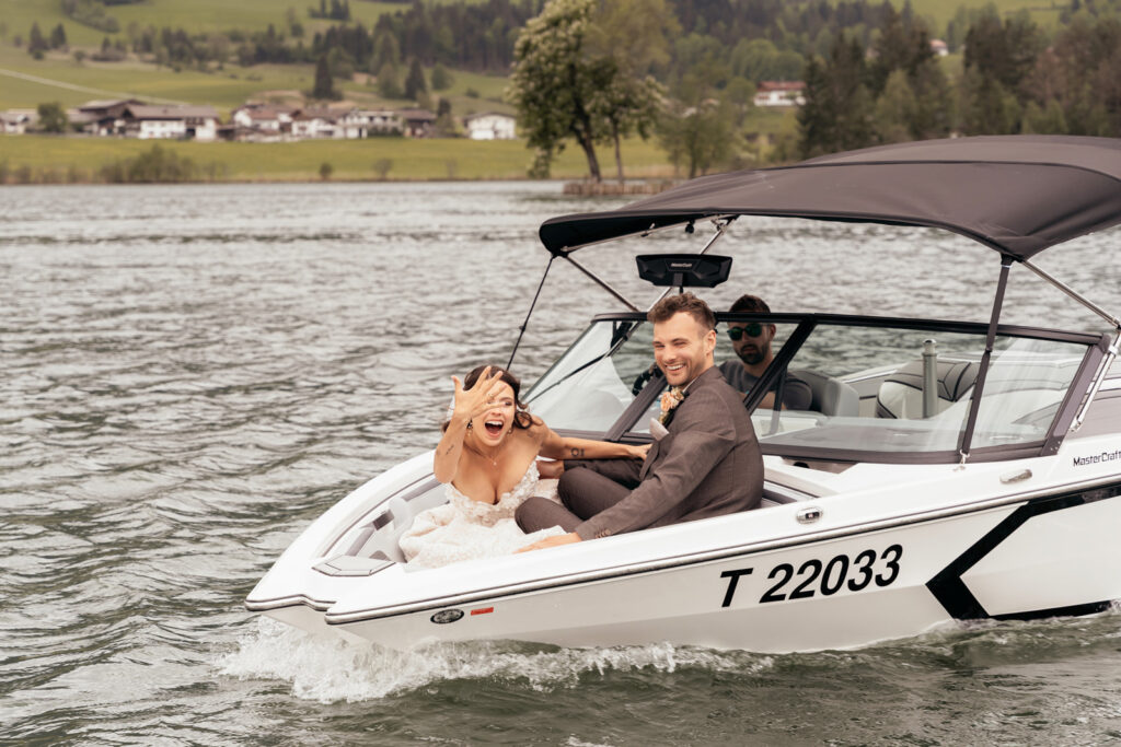 Brautpaar während stilvoller Bootsfahrt vor Tiroler Bergkulisse