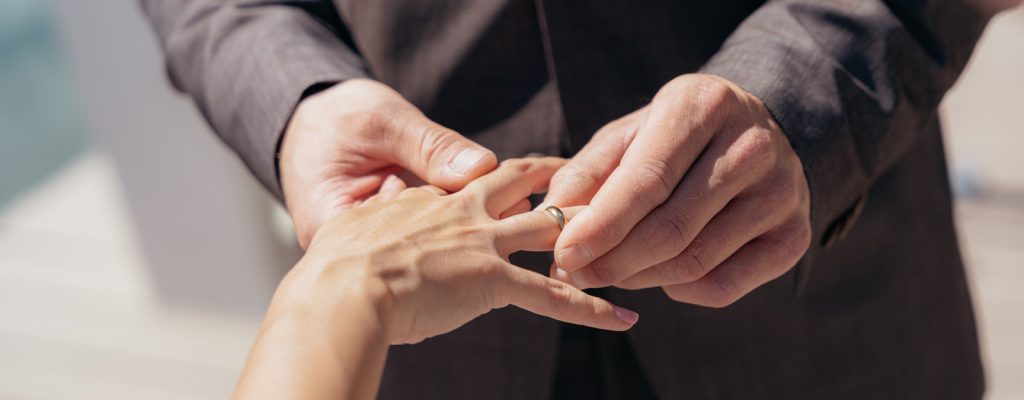 Hände des Brautpaares mit eleganten Eheringen bei exklusiver Hochzeit in Tirol